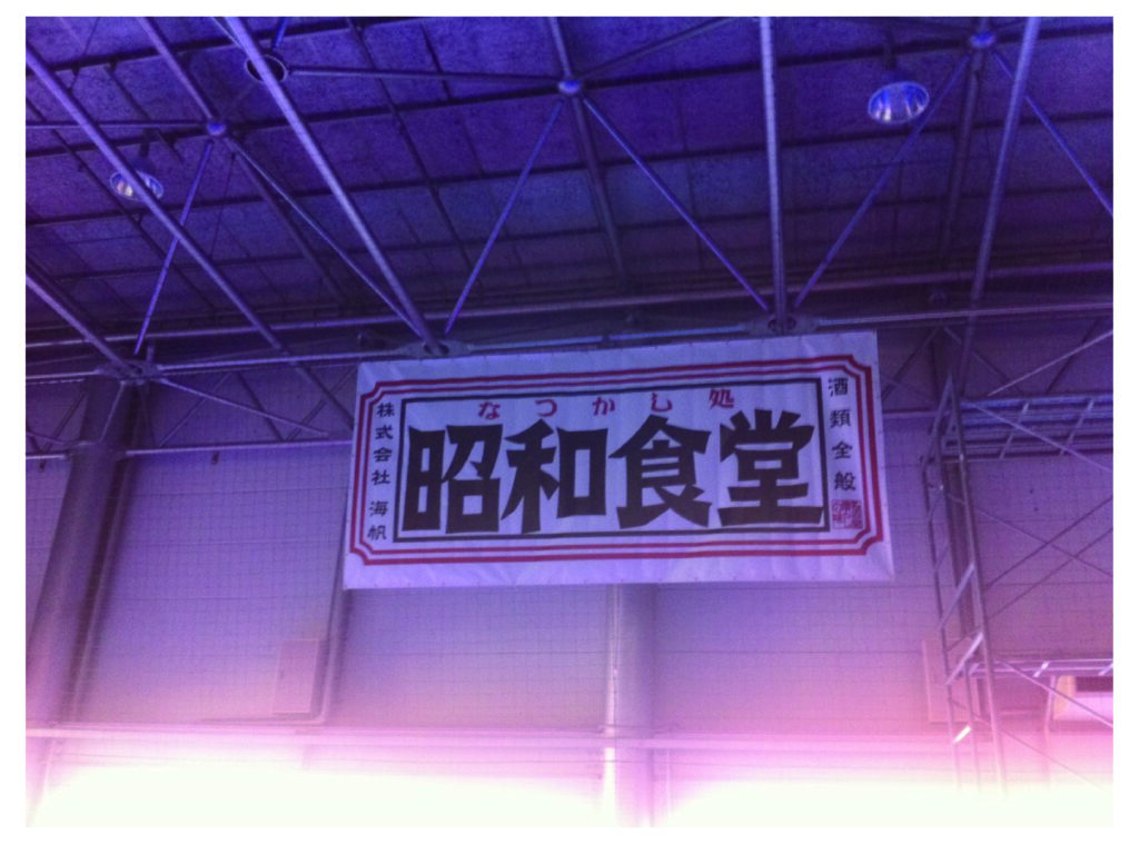 フットサル会場の天井パイプにターポリン印刷（マット仕上げ・W4800×H2400mm・ハトメ300ピッチ）で製作した大型スポンサー横断幕の施工事例