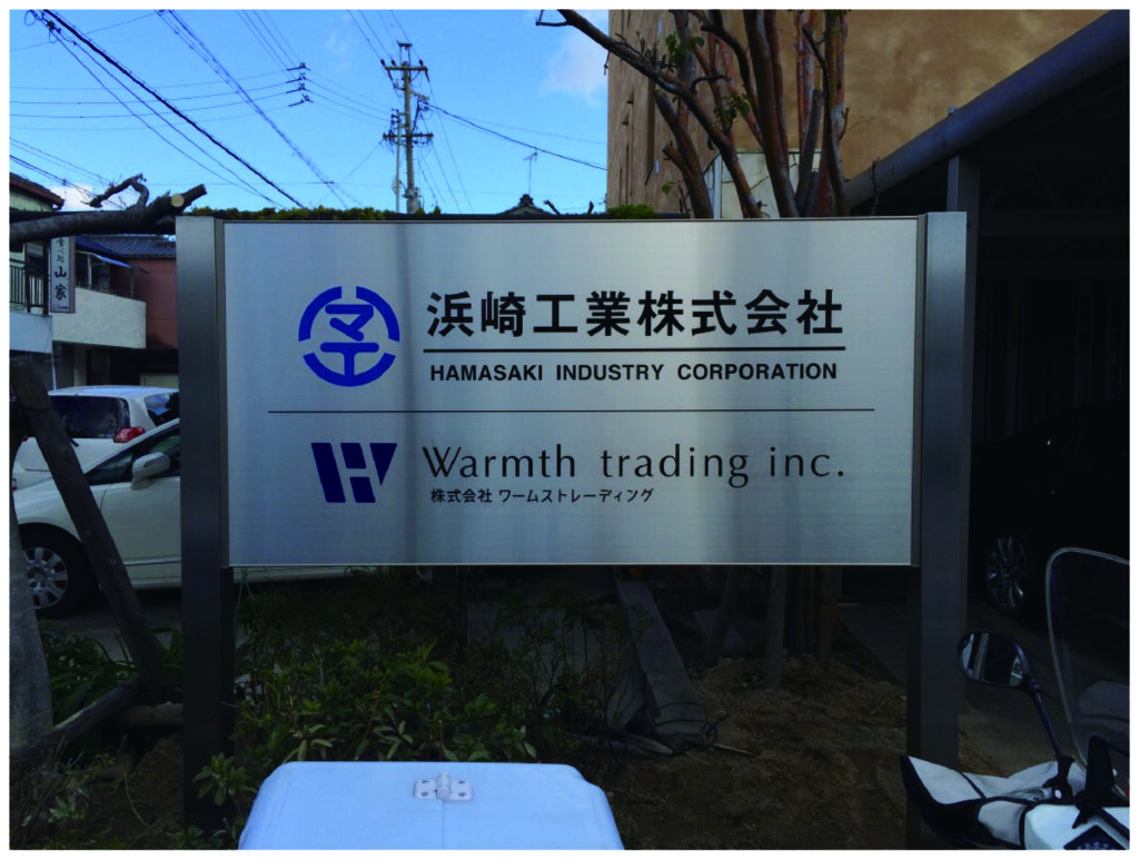 企業の社名・ロゴを塩ビシート輪郭カット印刷（切り文字）でリタックシート付きに製作し壁面に施工した看板シールの事例