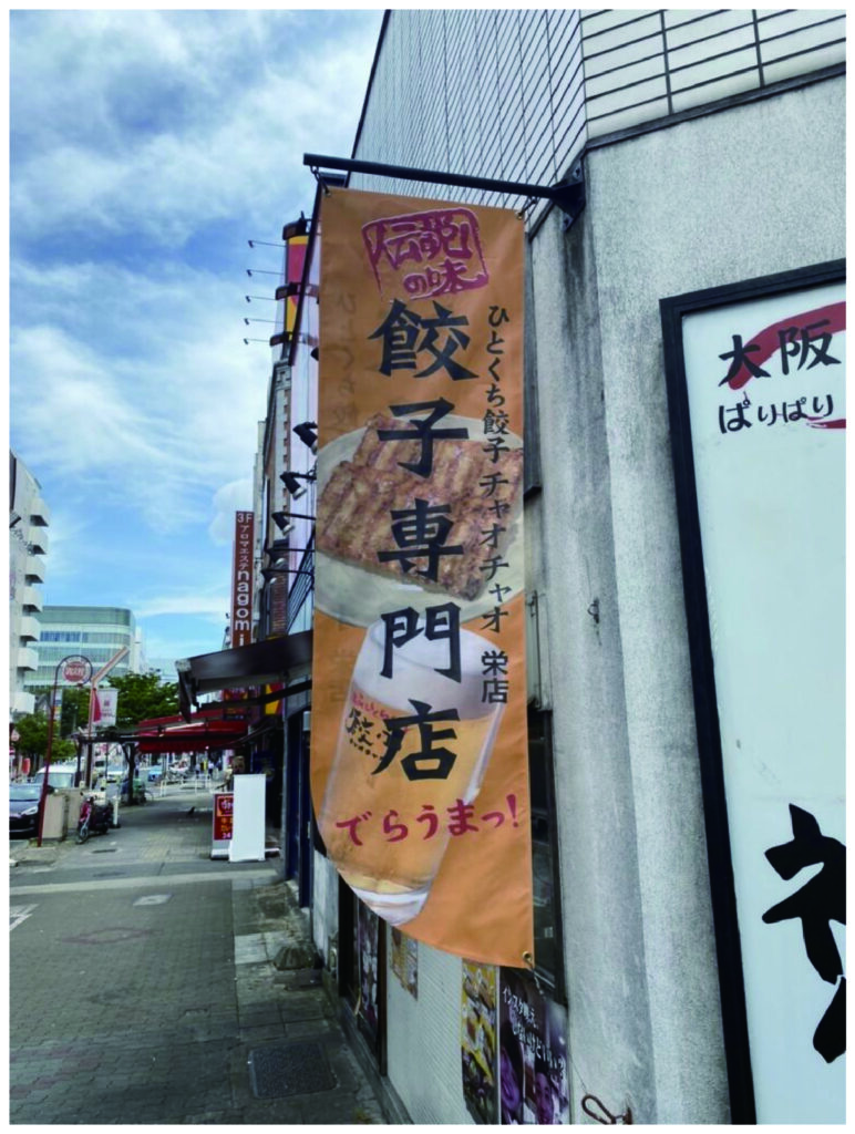 飲食店の屋外ポールにメッシュターポリン印刷（周囲縫製・ハトメ加工込み）で製作した大型告知幕の施工事例